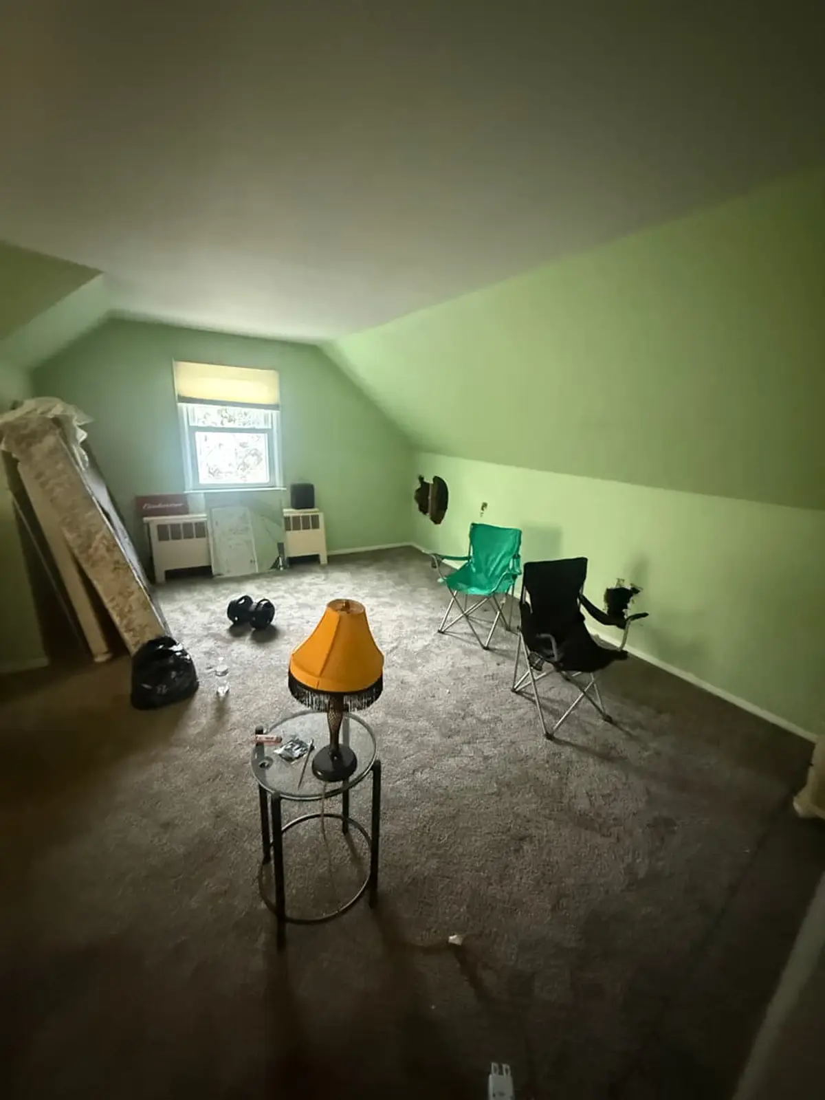 Selling estate property as an executor in Patchogue: attic bedroom with green walls and worn gray carpet