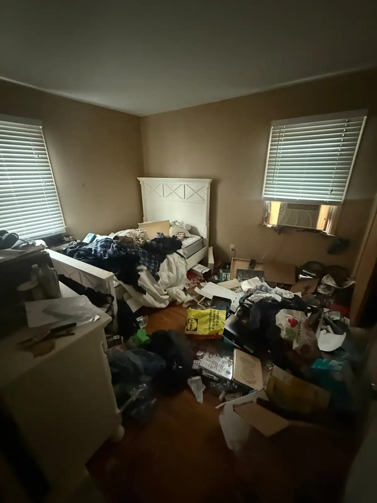 Selling a hoarder house in Patchogue: bedroom buried under bags, boxes and clothing