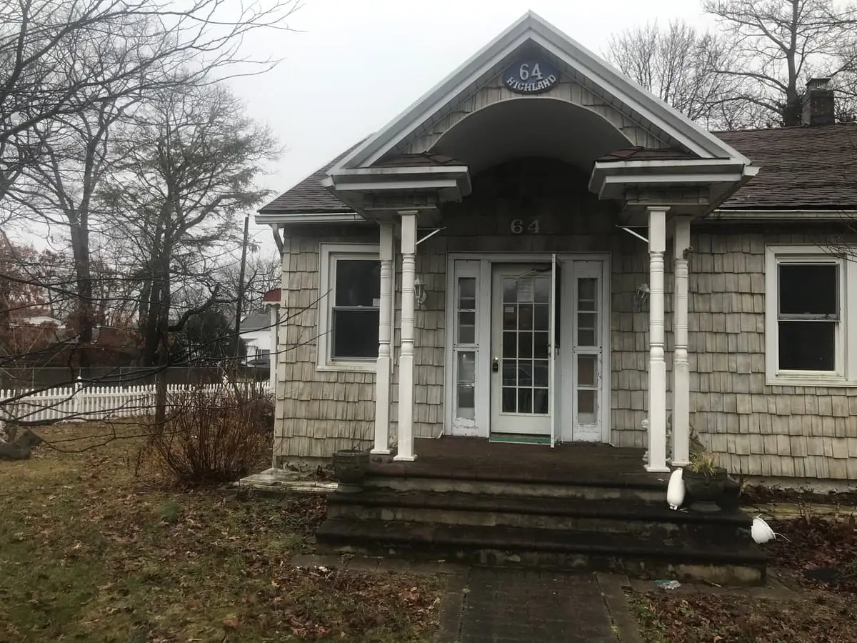 Trying to stop a foreclosure in Patchogue: shingled cottage with a columned front portico