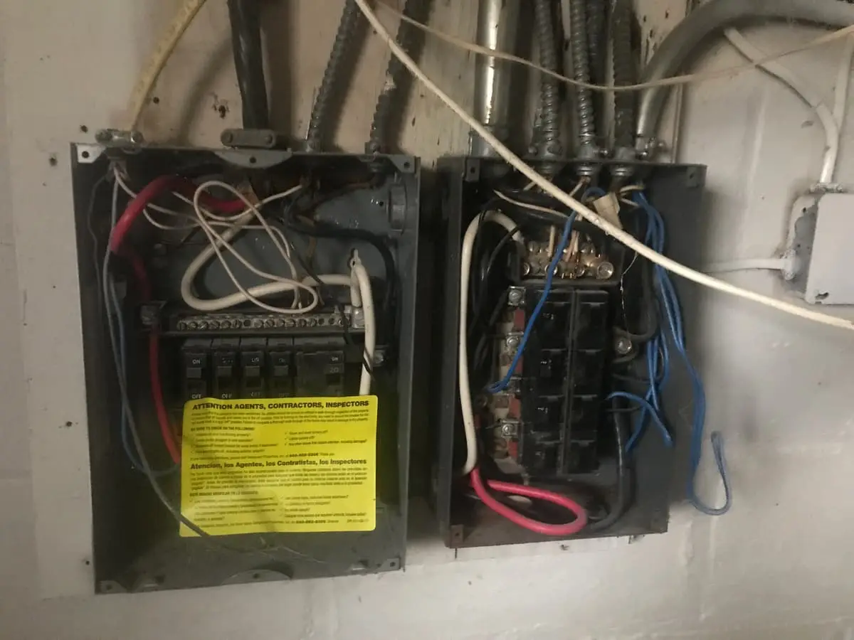 Selling a house with unpermitted work in Patchogue: two open electrical panels with exposed wiring